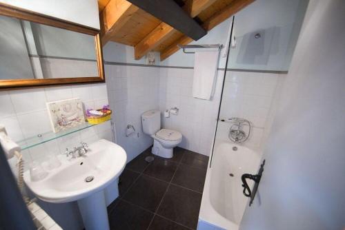 a bathroom with a sink and a toilet and a shower at Rustik Hostal Rural in Molinaseca