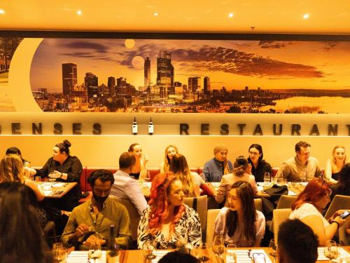 un grupo de personas sentadas en mesas en un restaurante en Novotel Perth Langley, en Perth