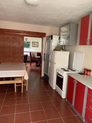 eine Küche mit roten Schränken und einem weißen Herd mit Backofen in der Unterkunft Vila Rakoč in Kolašin