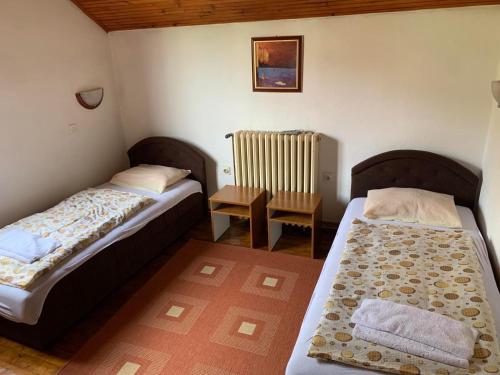 a small room with two beds and a chair at Vila Rakoč in Kolašin