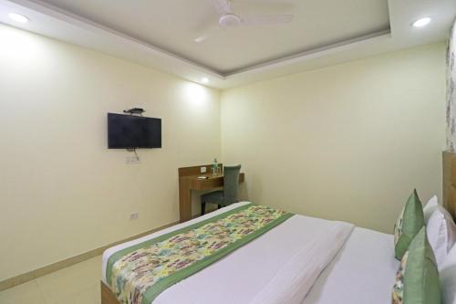 a bedroom with a bed and a flat screen tv at Hotel Grand Suites By D'Capitol Near IGI Airport in New Delhi