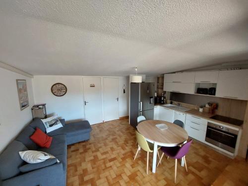 un salon avec un canapé bleu et une table dans l'établissement La Terrasse du Vénus - Port Vendres, à Port-Vendres