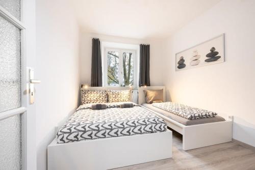 a white bedroom with a bed and a window at Apartment close to Theresienwiese in Munich