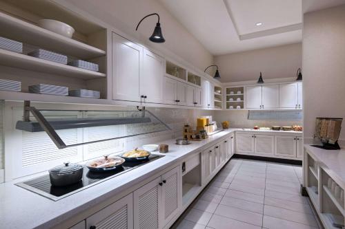 a large kitchen with white cabinets and a counter top at Hyatt Place Greensboro Downtown in Greensboro