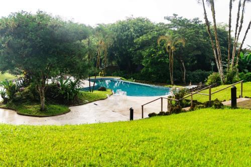 a swimming pool in the middle of a lush green field at Royal Palm Galapagos, Curio Collection Hotel by Hilton in Bellavista
