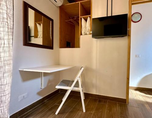 einen Schreibtisch in einem Zimmer mit einem Stuhl und einem TV in der Unterkunft Casa le Maioliche by Housilia in Cefalú