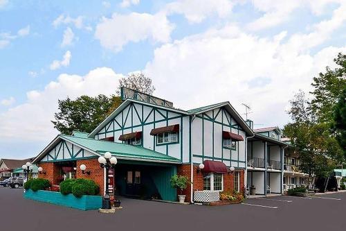 a building in a parking lot next to a building at Super 8 by Wyndham Gananoque - Country Squire Resort in Gananoque