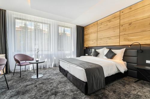 a bedroom with a large bed and a desk and chair at B THE HOTEL in Sfântu-Gheorghe