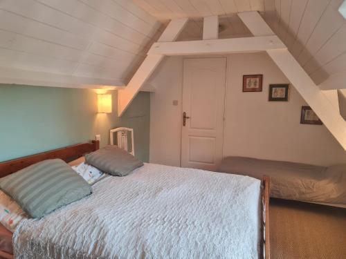 ein Schlafzimmer mit einem großen Bett im Dachgeschoss in der Unterkunft CHAMBRE D'HOTE AU MOULIN DE LONGUEIL in Longueil