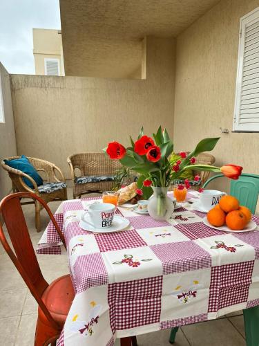 una mesa con un mantel con flores y naranjas. en Sole&Mare, en Villaggio Azzurro