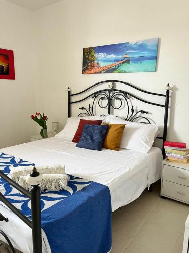 1 dormitorio con 1 cama grande con sábanas azules y blancas en Sole&Mare, en Villaggio Azzurro