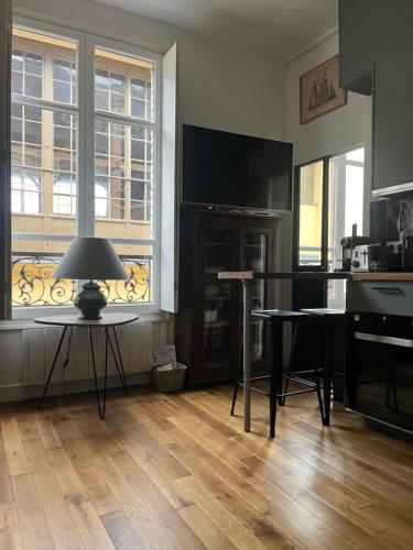 un salon avec une télévision et une table avec une lampe dans l'établissement Fabuleux Versailles chateau, à Versailles