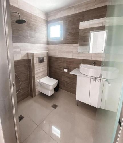 a bathroom with a toilet and a sink at Elvi Apartment 4 in Rakhónion
