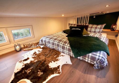 1 dormitorio con cama y alfombra en el suelo en Tiny House KlitzeKlein am Waldrand von Elpe, en Olsberg