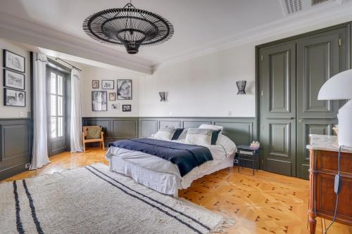1 dormitorio con cama y lámpara de araña en Very Beautiful family house with pool, en Burdeos
