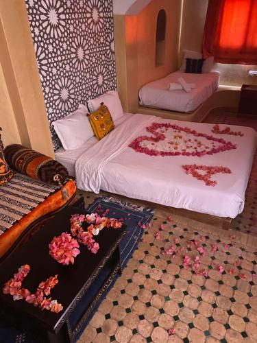 a room with two beds and flowers on the floor at Dar Rio Oro in Dakhla