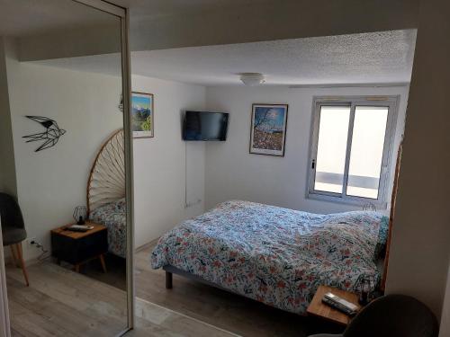 une chambre avec un lit, une fenêtre et un miroir dans l'établissement La Terrasse du Vénus - Port Vendres, à Port-Vendres