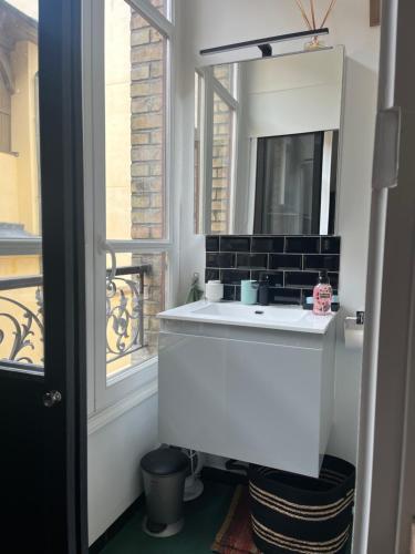 une salle de bain avec un lavabo blanc et un miroir dans l'établissement Fabuleux Versailles chateau, à Versailles