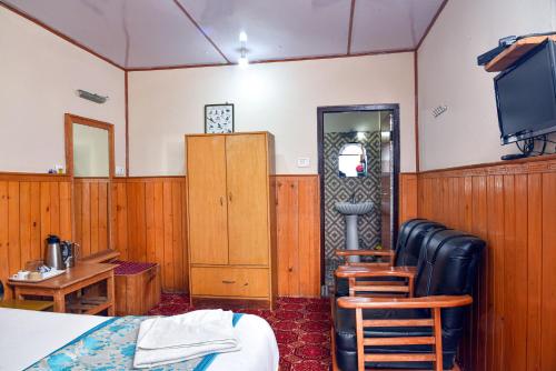 a room with a bed and a desk and a tv at Rufina Royal Lachung in Lachung