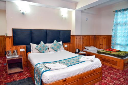 a bedroom with a large bed with a blue headboard at Rufina Royal Lachung in Lachung