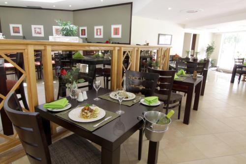 a dining room with a table with plates of food at Cresta Lodge Gaborone in Gaborone