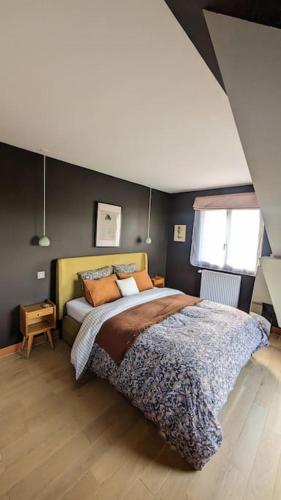 une chambre avec un grand lit dans une pièce dans l'établissement Villa Brunelle, Vue bords de Rance, à Le Minihic-sur-Rance