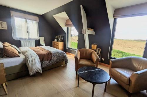 a bedroom with a bed and a chair and windows at Villa Brunelle, Vue bords de Rance in Le Minihic-sur-Rance