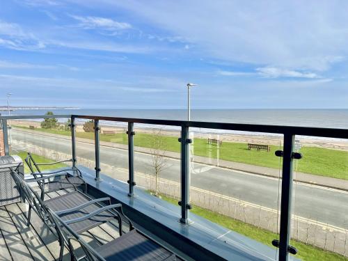 a balcony with chairs and a view of the beach at Shoreside Villa, by the Golf Course in Bridlington