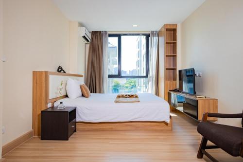 a hotel room with a bed and a window at Ramada Ekamai in Bangkok