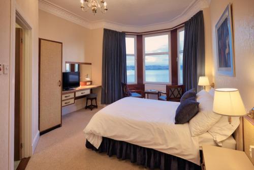 a hotel room with a bed and a large window at The Cedars Guest House in Dunoon