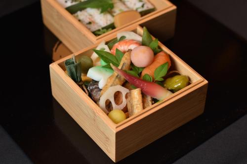 two wooden boxes filled with different types of food at Sora Niwa Terrace Kyoto in Kyoto