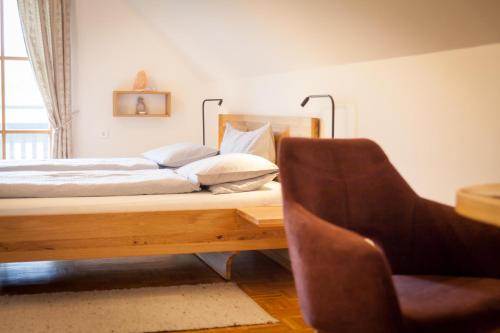 een slaapkamer met een bed op een bureau met een stoel bij Weingut spitzyPeitler in Leutschach