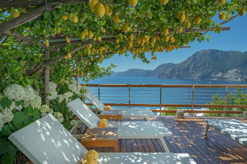 a group of tables on a deck with a view of the water at Casa Angelina in Praiano