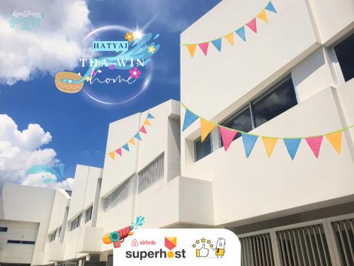a white building with colorful flags on it at This house is not open right now Tha-win Home-City Charm Adventure with stylish Hat Yai retreat in Hat Yai