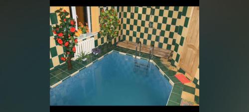 una pequeña piscina en una casa con flores en Valeriu en Leova