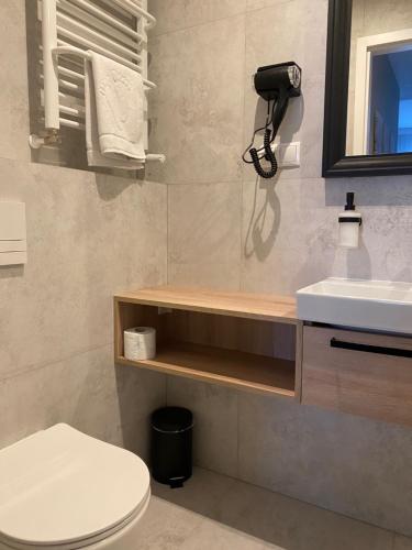 a bathroom with a toilet and a sink at Apartamenty Wolności 6 self check-in 24h in Poznań