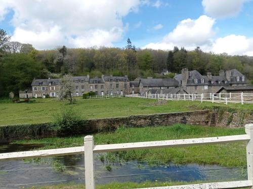 a view of a village with a white fence at Les hébergements insolites de Quénécan in Perret