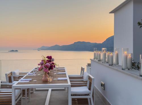 a table with flowers in a vase on a balcony at Casa Angelina in Praiano