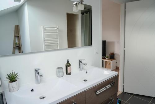 a bathroom with a white sink and a mirror at Sunset Villa - La maison des couchers de soleil in Villaz