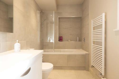 a bathroom with a tub and a toilet and a shower at Secluded woodland annex between Mylor and Flushing in Falmouth