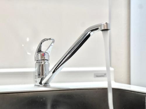 a kitchen sink with a water faucet at YIAN-Kamiochiai house in Tokyo