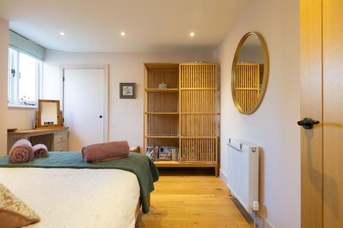 a bedroom with a bed and a mirror on the wall at Secluded woodland annex between Mylor and Flushing in Falmouth