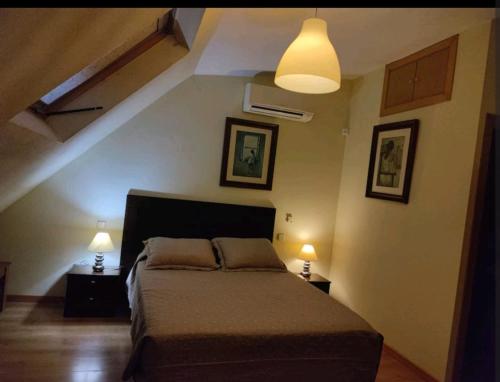 1 dormitorio con 1 cama y 2 luces en la pared en apartamento noviembre, en Madrid