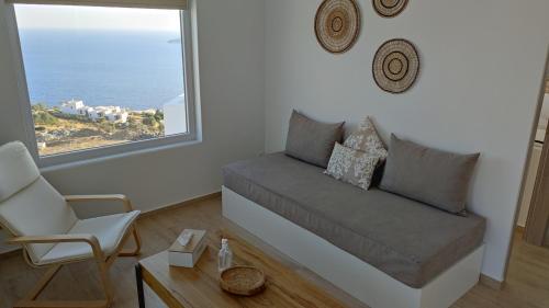 sala de estar con sofá y ventana grande en Eolia luxury houses Andros, en Batsi