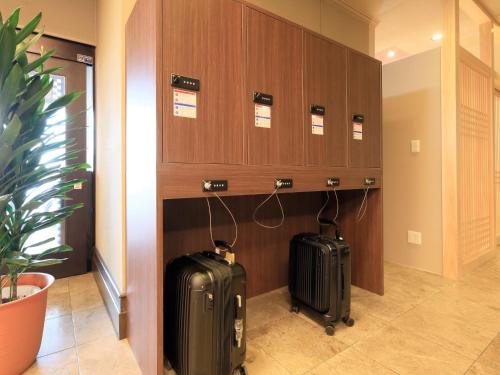 two suitcases are sitting in a hallway at Kishigon Ryokan in Shibukawa