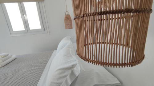 1 dormitorio con 1 cama con silla junto a una ventana en Eolia luxury houses Andros, en Batsi
