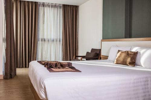 a hotel room with a bed with a towel on it at Ramada Ekamai in Bangkok