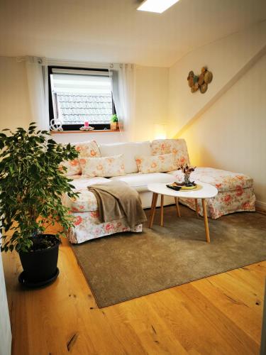 ein Wohnzimmer mit einem Sofa und einem Tisch in der Unterkunft Kleine Auszeit in Amelinghausen