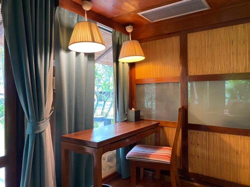 a home office with a wooden table and a window at Centara Koh Chang Tropicana Resort in Ko Chang