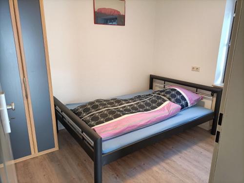 ein kleines Bett mit einer Decke auf dem Zimmer in der Unterkunft Apartment Bamboleo in Veringendorf